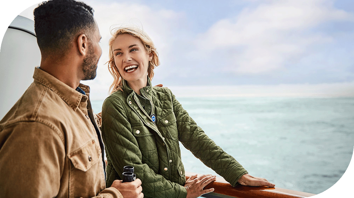 A couple enjoys their view from a Princess ship balcony.
