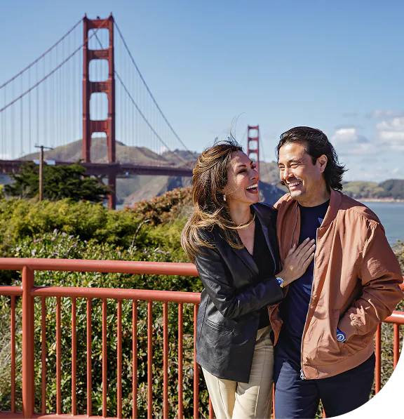 Couple laughing in front of the Golden Gate Bridge in San Francisco, California.