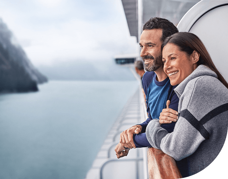A couple enjoys their cruise on the balcony of a Princess ship in the Inside Passage, Alaska