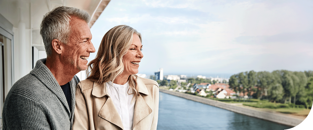 A couple enjoys a balcony view of Warnemunde, Germany, onboard a Princess ship.