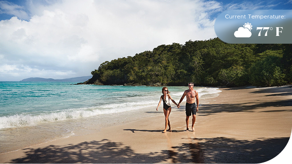 Couple holding hands walking across beach in St. Thomas