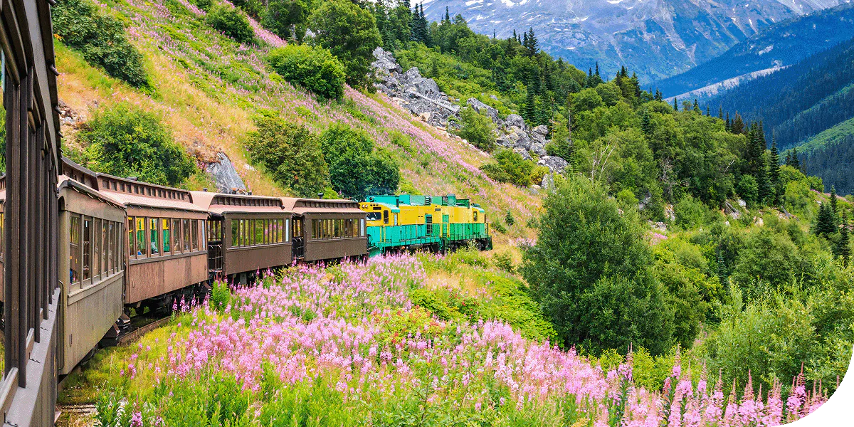 A train travels alongside the hills of Skagway, Alaska.