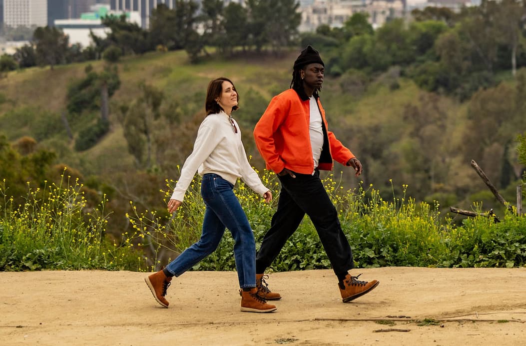 Two people walking along a well-worn dirt trail wearing Logger 917 boots. 