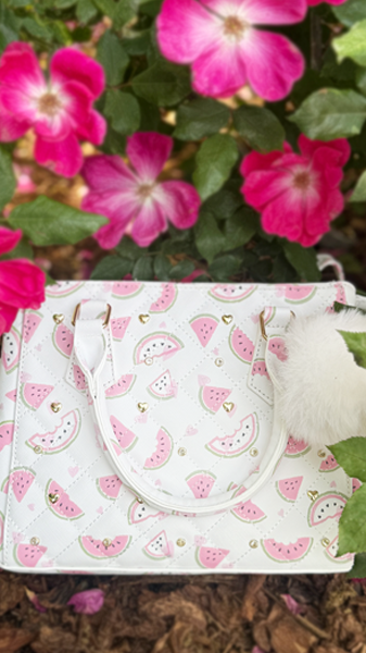 White with pink watermelon print bag in garden. 