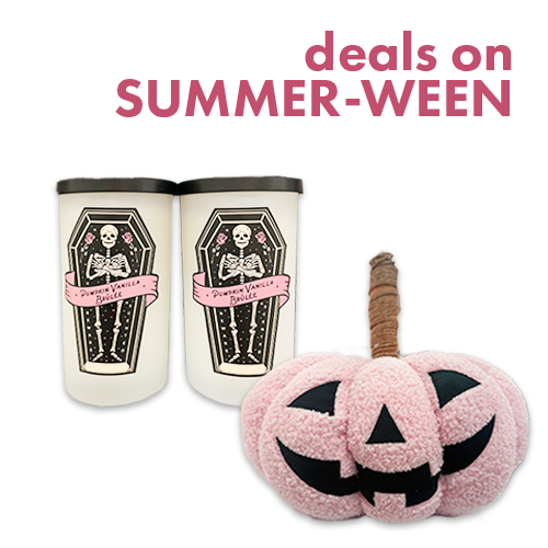 White candles with a skeleton and pink jack-o-latern pillow.