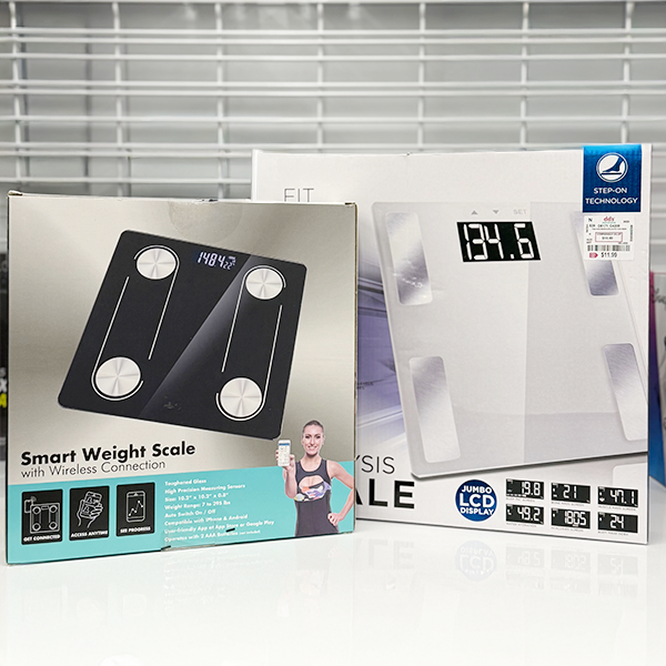 Retail packaging for two digital bathroom scales, including a smart scale with wireless connection and a glass scale with a large LCD display.
