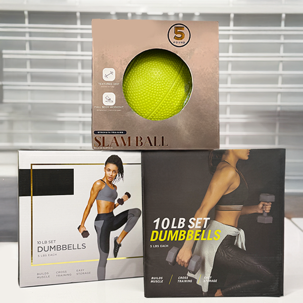 Retail packaging showing a five-pound slam ball placed on top of two ten-pound dumbbell sets.