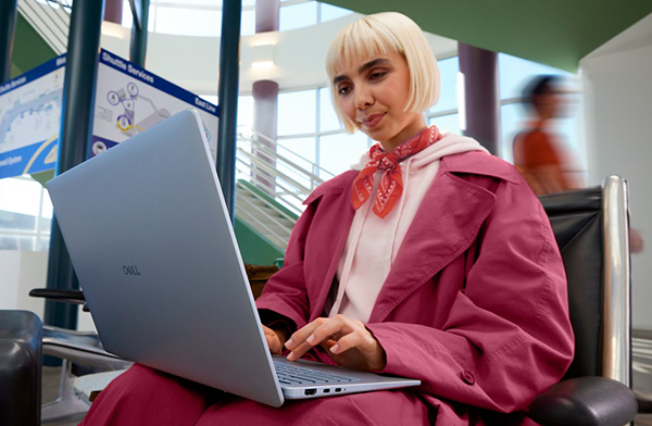 Person using Dell 14 Plus laptop in transit station.