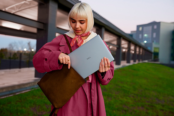 Person using Dell 14 Plus laptop in transit station.