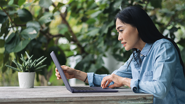 Woman working outside using a Dell 14 Plus Non-Touch Laptop
