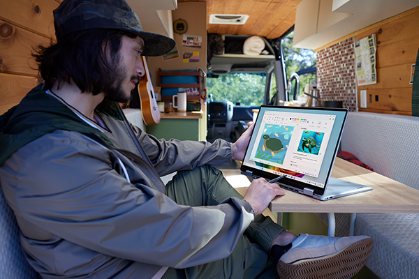 Person using the Dell 16 Plus 2in1 in a camping van