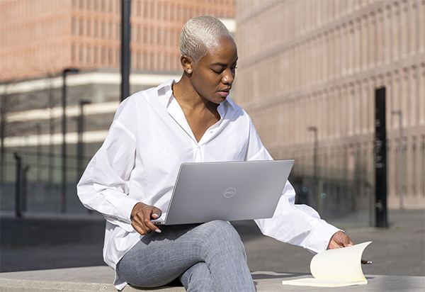Professional Working on a Laptop Outside an Office Building