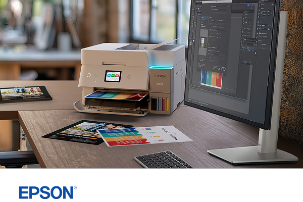 An Epson EcoTank color printer on a desk next to a Dell monitor and keyboard.