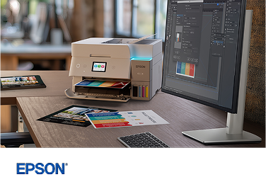 An Epson EcoTank color printer on a desk next to a Dell monitor and keyboard.