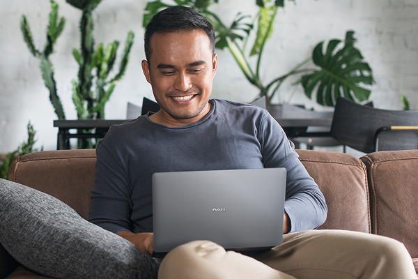 A person at home enjoying working on a Dell laptop.