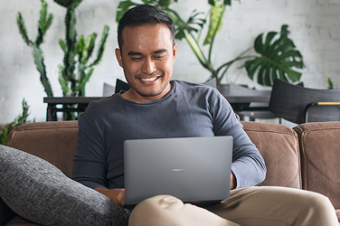 A person at home enjoying working on a Dell laptop.