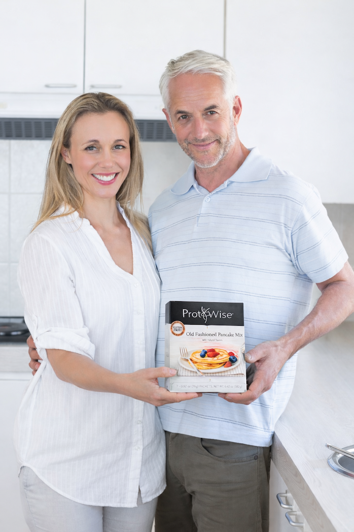 an image of a man and woman holding a box of fruit