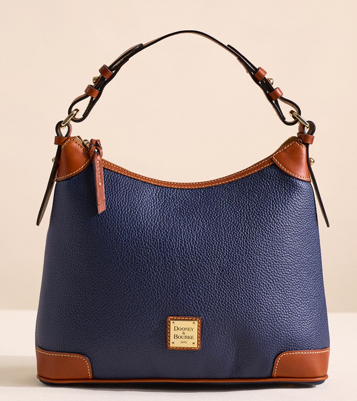 The Pebble Grain Hobo offers ample space for your daily essentials without feeling bulky. It easily fits a standard iPad, full-size wallet, sunglasses case, makeup pouch, phone, and keys, with room left for a small notebook or charger. A zip pocket secures valuables, while two interior slip pockets and a dedicated cell-phone pocket keep smaller items organized. The key hook ensures you'll never dig for your keys, and the top zipper closure keeps everything safely contained. Spacious enough to fit your iPad, wallet, and daily must-haves, yet sleek enough for everyday wear, the Pebble Grain Hobo combines DooneyÕs iconic craftsmanship with functional, timeless style.