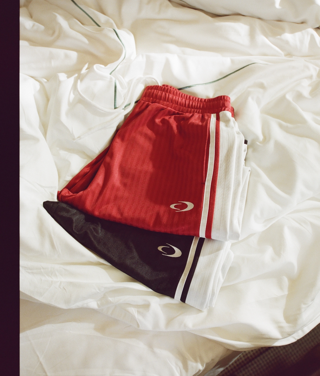 an image of a bed with a pair of red and black track pants