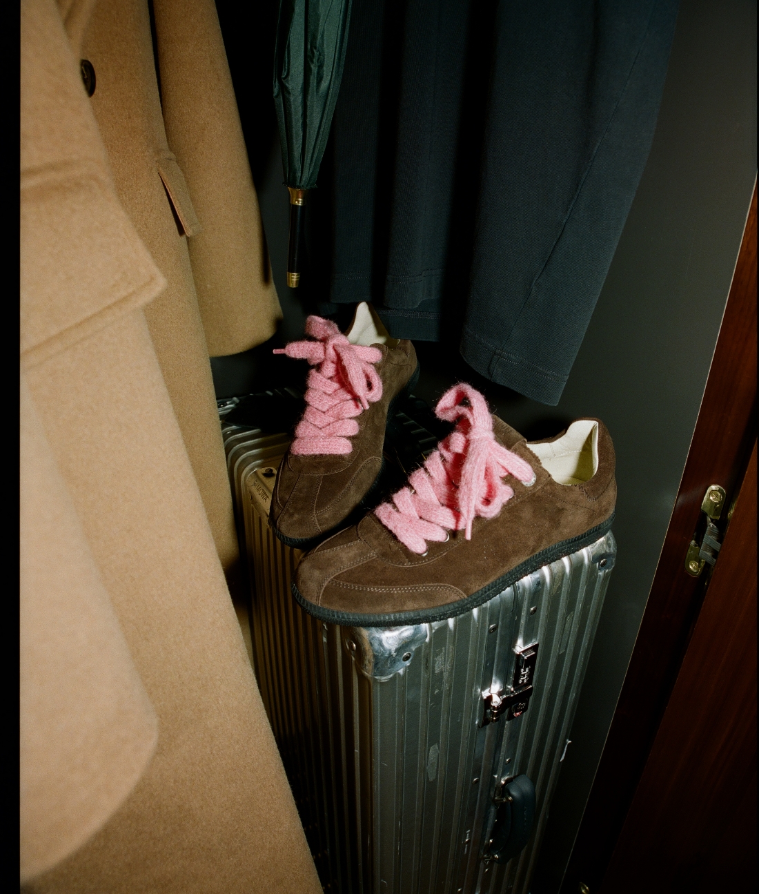 an image of a pair of shoes with pink laces on a suit case
