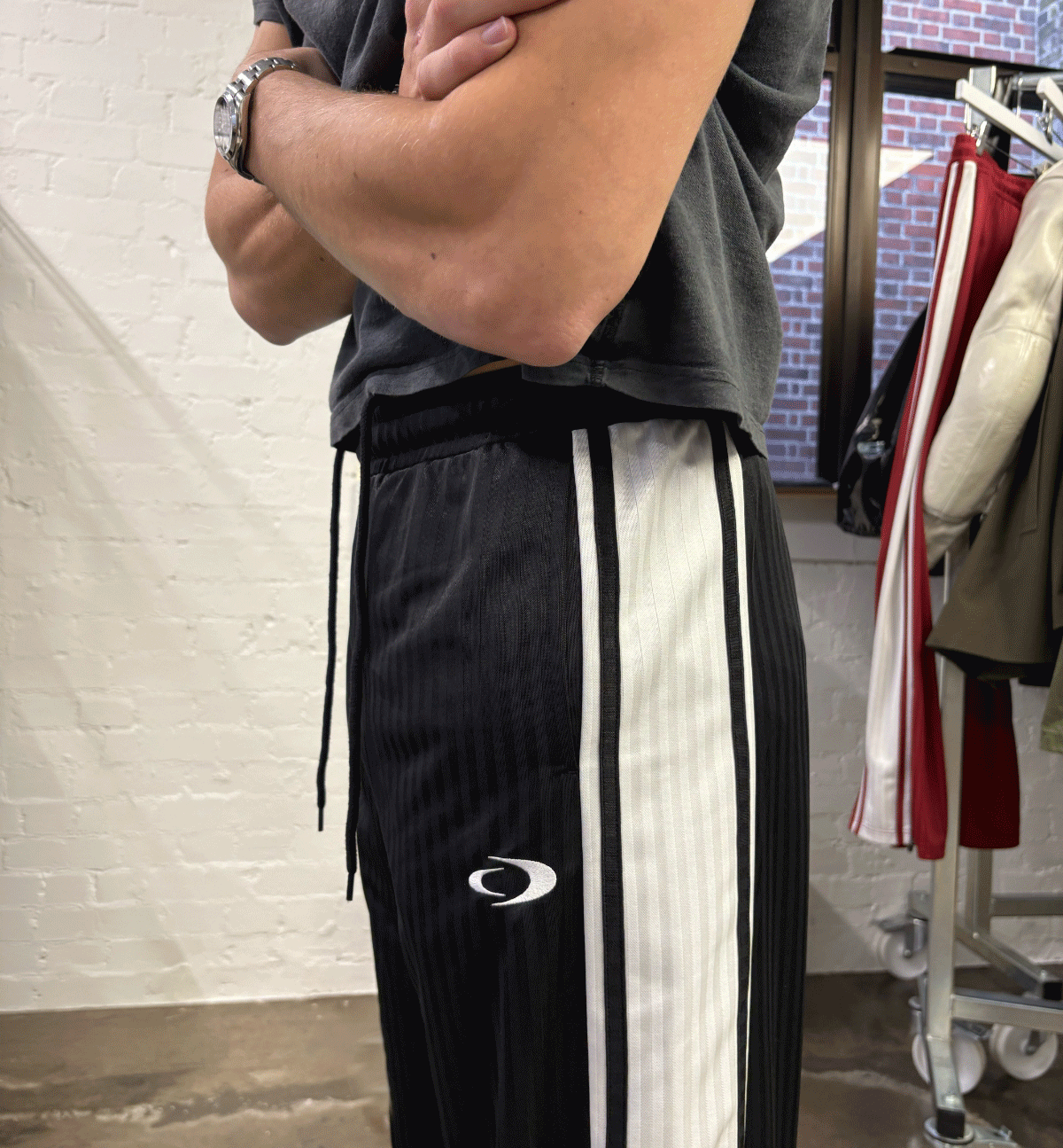 an image of a man standing in a clothing store with his arms crossed