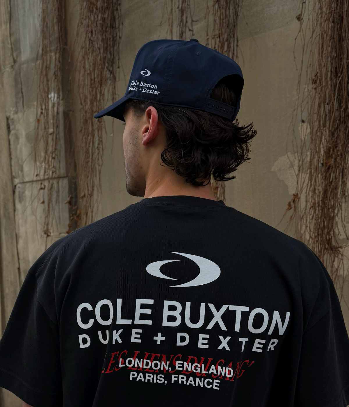 an image of a man wearing a black shirt and a hat