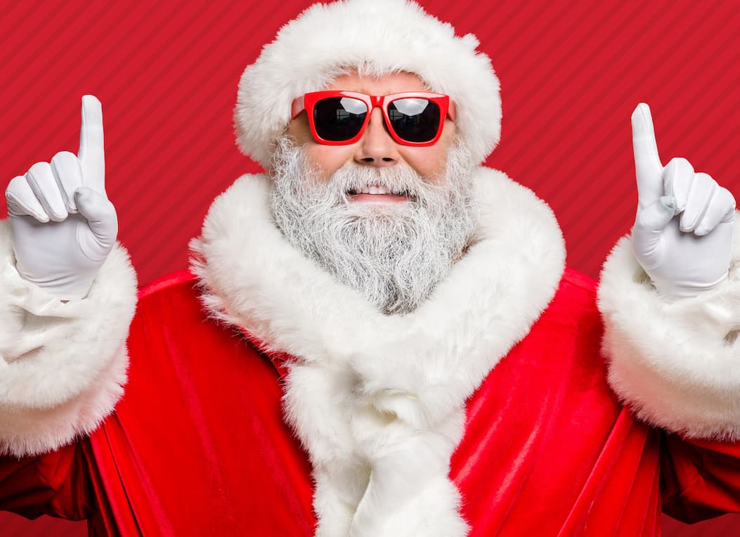 Santa Claus pointing up on a holiday background.