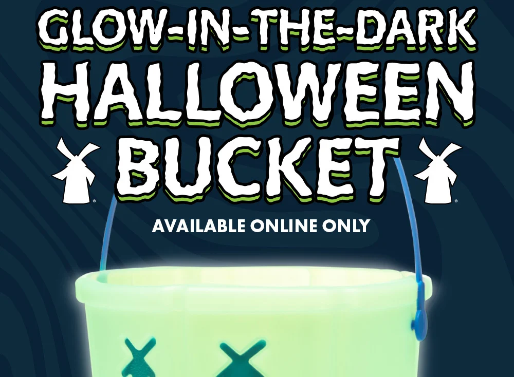 Glow-in-the-dark Halloween Bucket | Available online only | Pictured is a green glowing halloween bucket against a dark patterned background