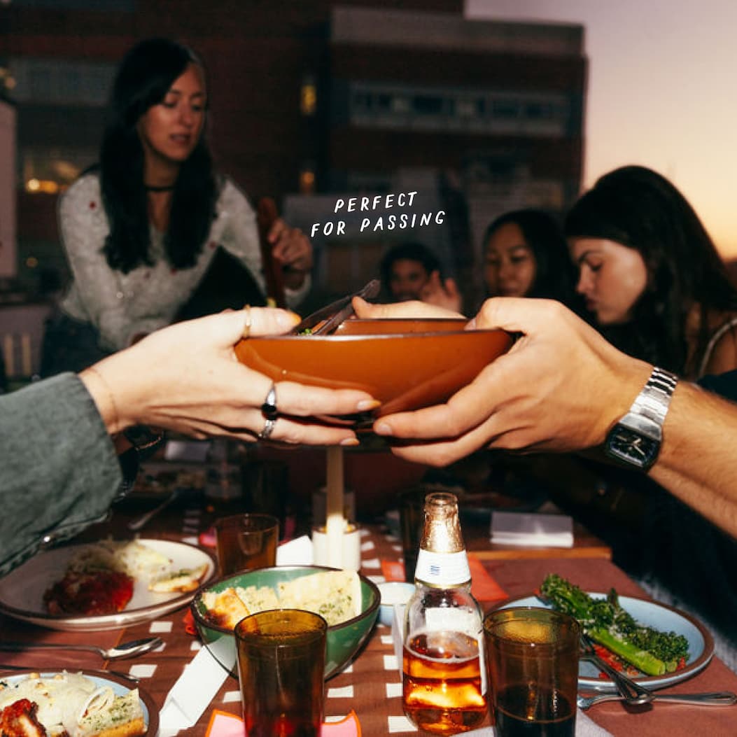 A bowl is passed between hands across a table