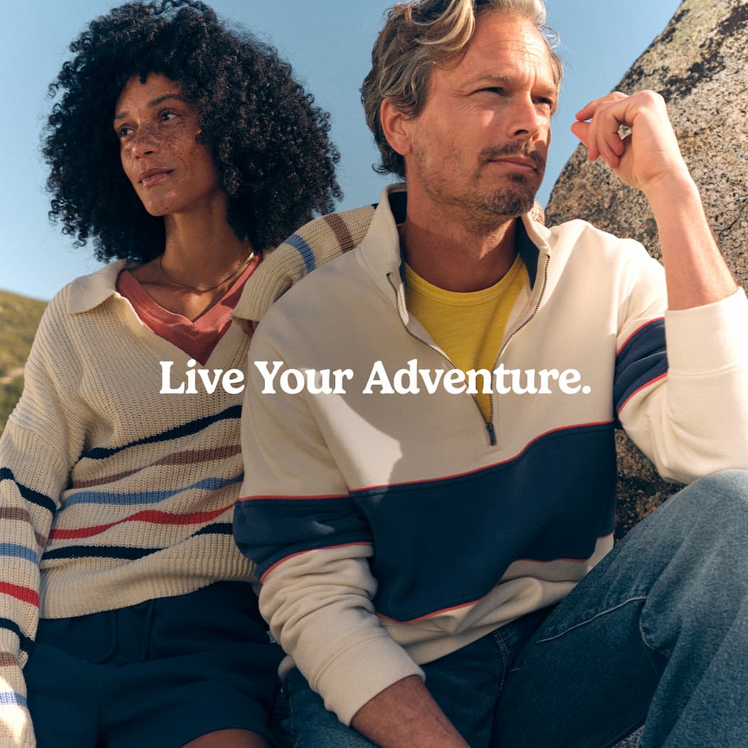 Man and Women in Outdoor Gear sitting in back of car. 