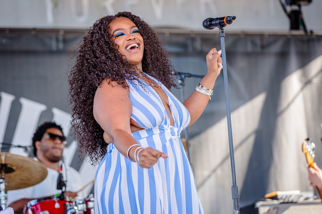 a woman singing in front of a microphone on a stage