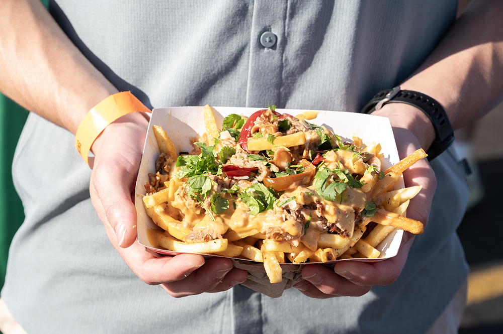 a person holding a bowl of nachos in his hands