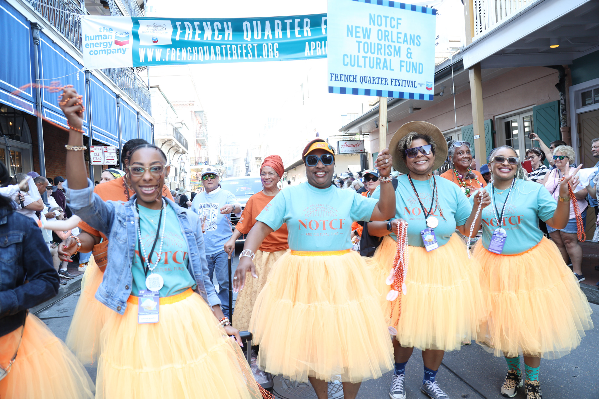 a group of women in orange costumes walking in a parade