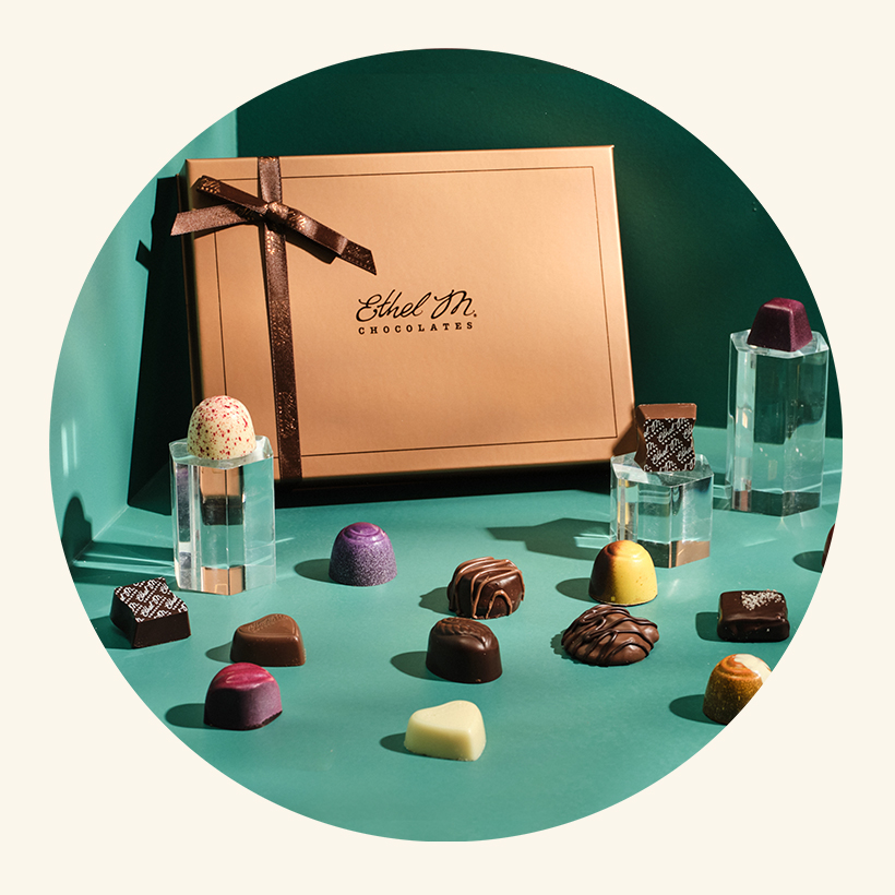 Ethel M Chocolates Custom Chocolate Box with a variety of chocolate gems placed around the box.