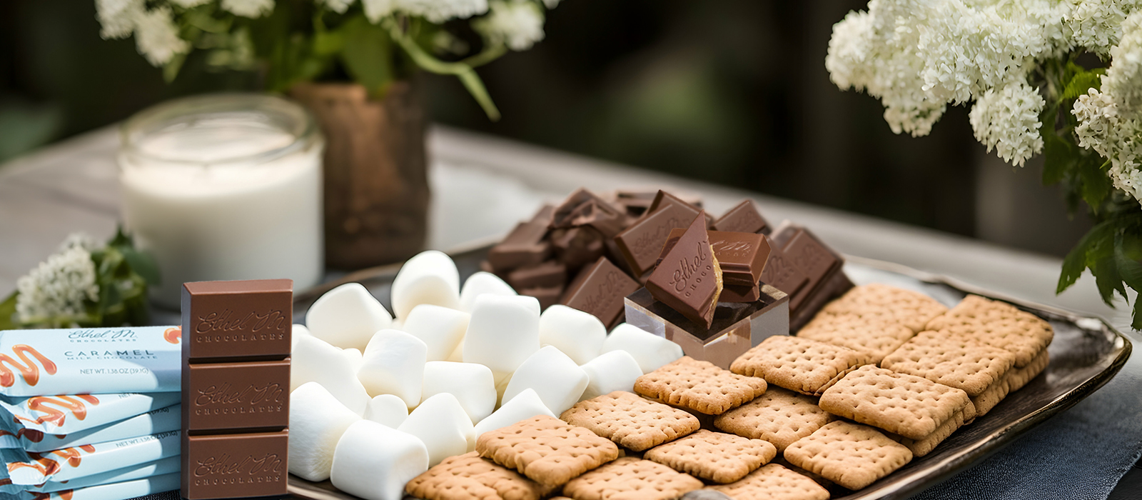 Ethel M Chocolates gourmet chocolate bars on a platter with marsh mellows and graham crackers.