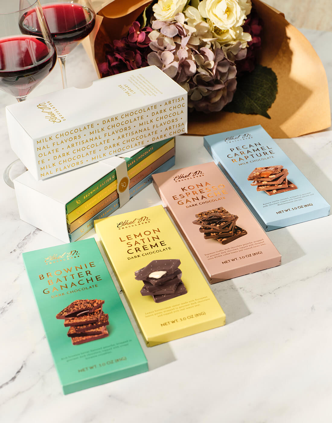 Ethel M Chocolates luxe library laid out to showcase the four flavors included. Brownie Batter Ganache, Lemon Satin Creme, Kona Espresso Ganache, and Pecan Caramel Rapture