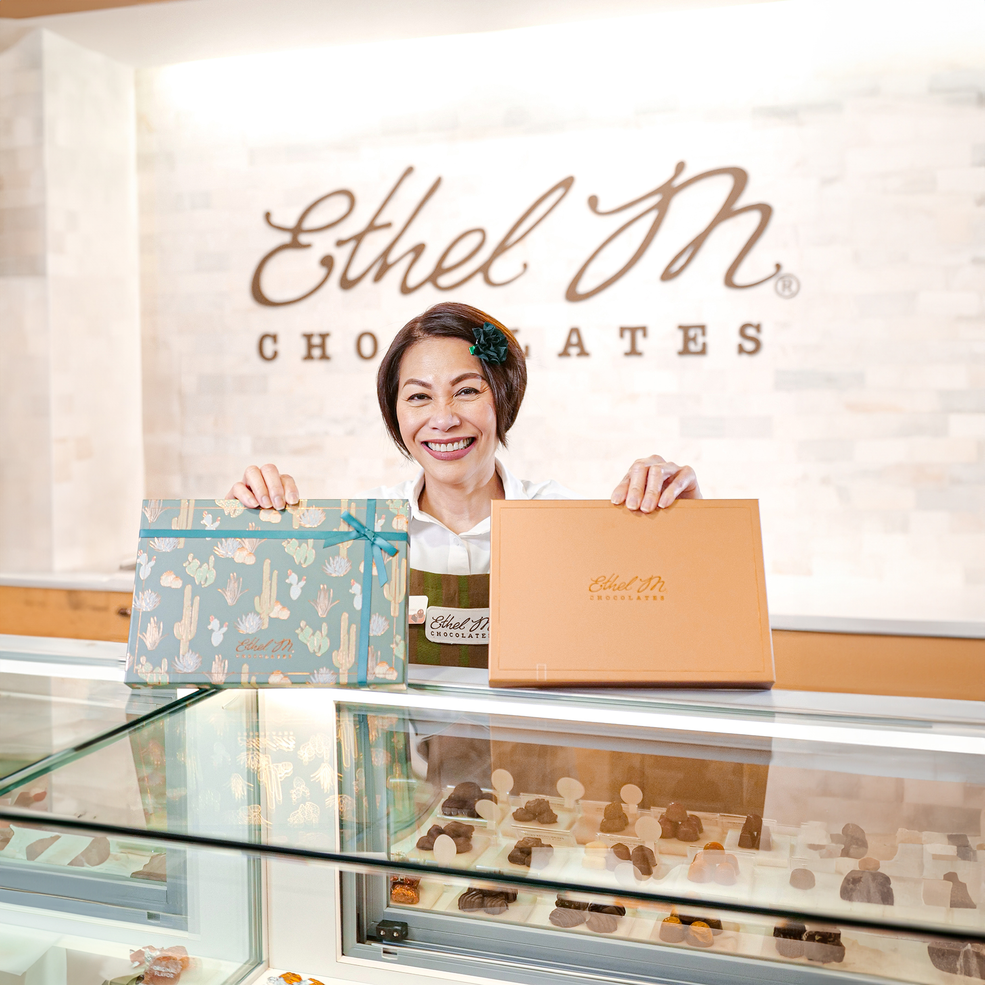 Store Associate serving Ethel M Chocolates at the counter.