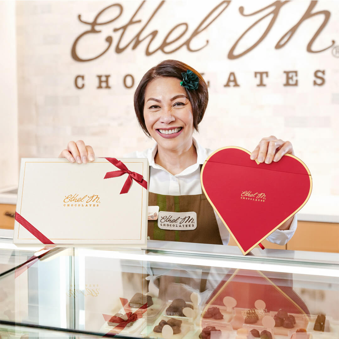 Store Associate serving Ethel M Chocolates at the counter.