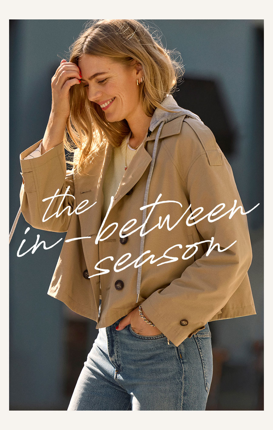 The in-between season. Image of model in short trench and jeans.