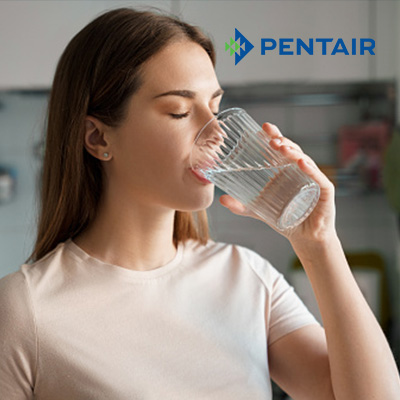 Woman drinking water filtered by Pentair Home Water Filtration System