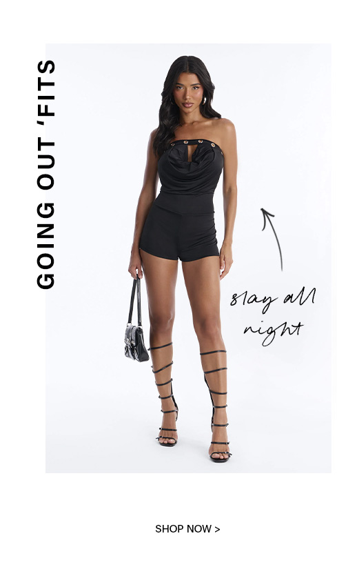 Elegant woman in a black strapless cowl neck going out romper with shorts, paired with lace-up heels and a small bag. Shop stylish clubwear looks.