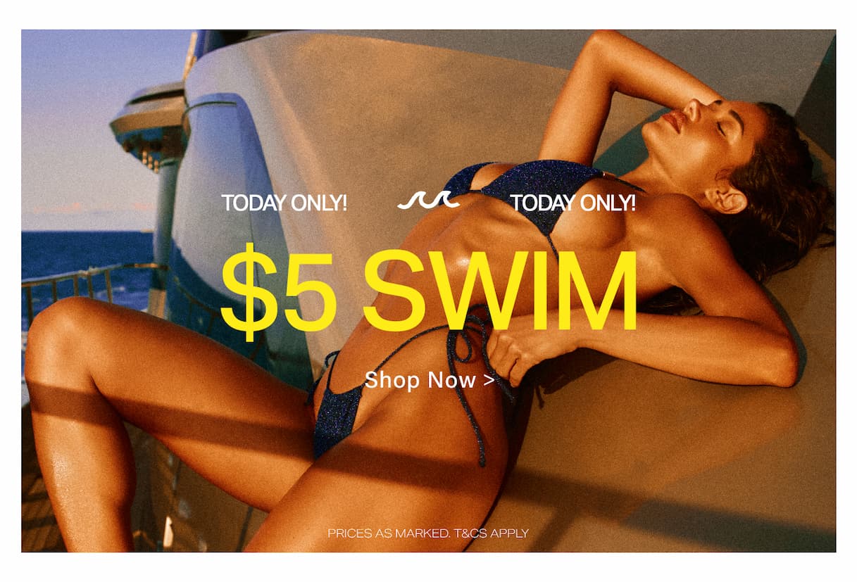 Reclining woman in a sparkling dark blue bikini on a boat, promoting the 'Today Only! $5 Swim' sale. Shop beachwear now!