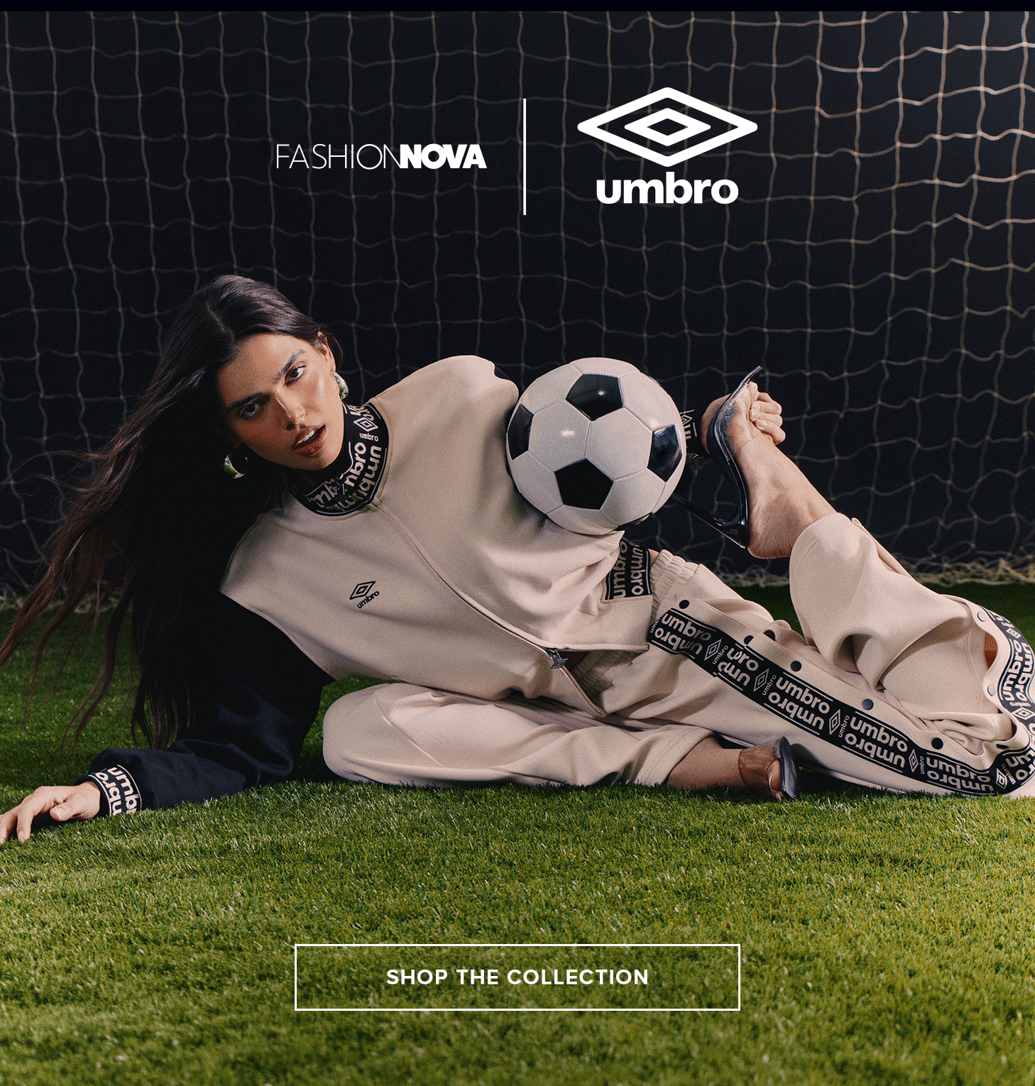 Fashion Nova & Umbro collaboration: Woman models beige athleisure tracksuit with soccer ball on grass. Shop the collection.