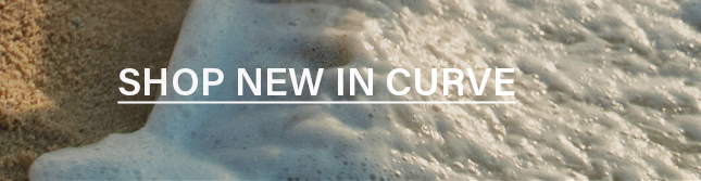 Foamy ocean wave receding on golden sand, featuring "SHOP NEW IN CURVE" text. Discover the latest plus size fashion collection.