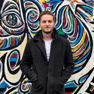 2023 Big Break Winner Jason Kaleko stands in front of a multi-colored graffiti art background