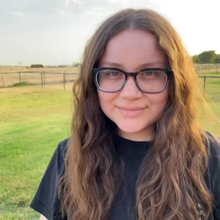 2022 Big Break Winner Natalie Wood stands in the countryside, green fields behind her