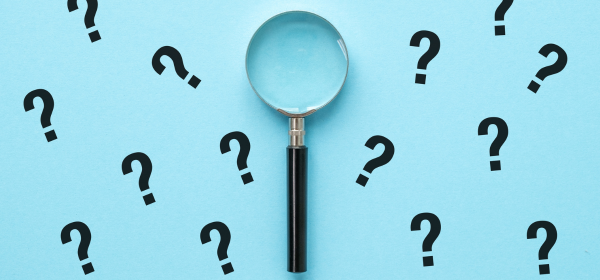 Image of a magnifying glass placed on a baby blue background with black question marks surrounding it