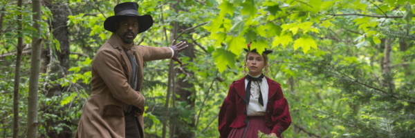 Image of Sterling K. Brown waving back towards Iola Evans to stop walking in a lush forest in Washington Black2