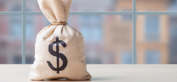 a burlap bag of money sitting on a white table