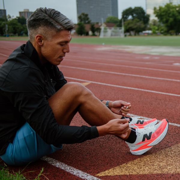 Man tying New Balance shoes